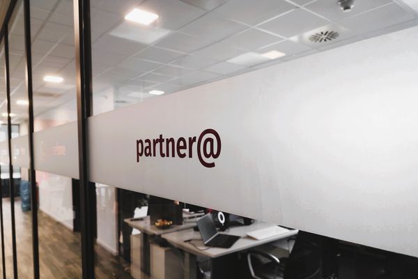 Glaswand mit peoplefone Partner Logo mit Blick ins Büro